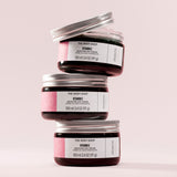 Three jars of The Body Shop Vitamin E Moisture Day Cream stacked on a light pink background