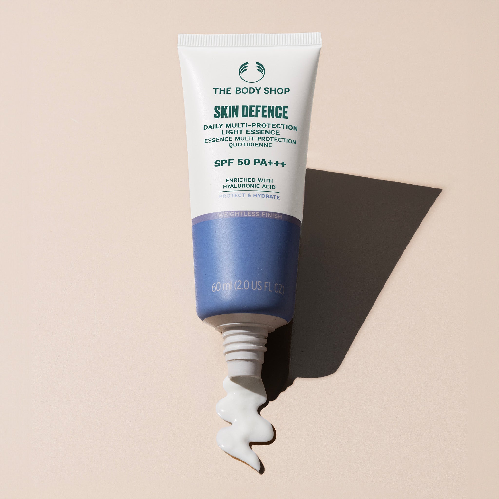 Tube of The Body Shop Skin Defence sunscreen on a beige background